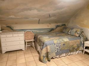a bedroom with a bed and a painting on the wall at Angie's Guest Cottage in Virginia Beach