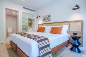 a bedroom with a large white bed with orange pillows at Aduana Suites in Salou
