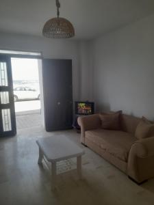 a living room with a couch and a coffee table at Au Soleil le Vent in La Goulette