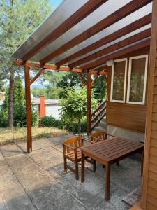 a wooden pergola with a picnic table and two chairs at Chata Dorka in Kamenica nad Hronom