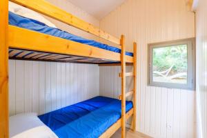 two bunk beds in a small room with a window at Chalet confort 4 piscine partagée in Les Vans