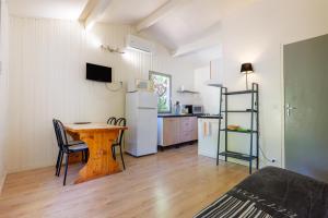 a kitchen and dining room with a table and a kitchen gmaxwell gmaxwell gmaxwell at Chalet confort 4 piscine partagée in Les Vans