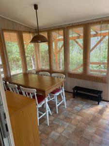 a dining room with a table and chairs and windows at Chata Dorka in Kamenica nad Hronom