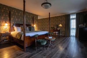 a bedroom with a bed and a table and chairs at Dumbleton Hall in Broadway