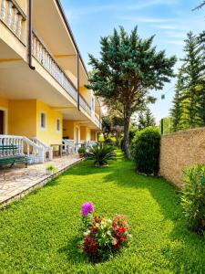a garden in front of a house with flowers at Hotel Marino in Baks-Rrjoll +14 photos