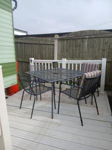 a table and two chairs on a wooden deck at Hillcrest hideaways2 in Hunmanby