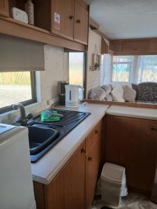 a kitchen with a stove and a sink in a caravan at Hillcrest hideaways2 in Hunmanby