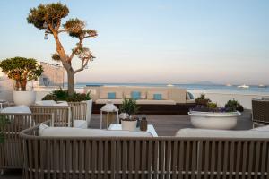 a patio with a couch and chairs and the ocean at La Chiaja art&relais in Castellammare di Stabia