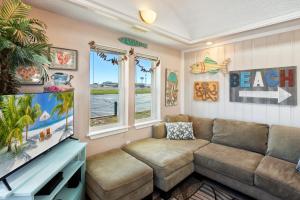 a living room with a couch and a flat screen tv at 5065 - Flip Flop Inn in Kill Devil Hills