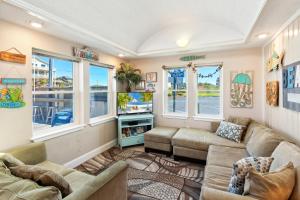 a living room with couches and windows at 5065 - Flip Flop Inn in Kill Devil Hills +16 photos