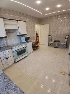 a large kitchen with white appliances and a table at California Stay in Amman