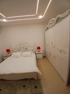 a bedroom with a white bed and two night stands at California Stay in Amman
