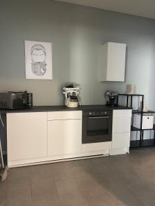 a kitchen with white cabinets and a black counter top at Loft character in Eggenstein-Leopoldshafen +36 photos