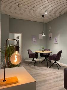 a room with a table and chairs and a lamp at Loft character in Eggenstein-Leopoldshafen