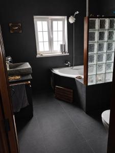 a black bathroom with a tub and a sink at Casa da Lua in Erra +31 photos
