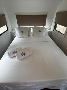 a white bed in a small room with towels on it at Roulotte Beach São Tomé in Triunfo