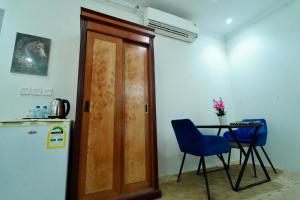 a kitchen with a door and a table and a refrigerator at فندق ندى الفيروز in Az Zāhir +10 photos