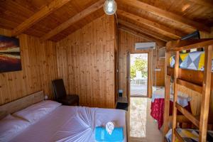 a bedroom with two bunk beds in a wooden cabin at Hotel Brigeni & Camping Riviera in Shëngjin +29 photos