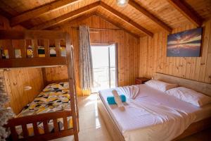 a bedroom with a bed and bunk beds in a room at Hotel Brigeni & Camping Riviera in Shëngjin