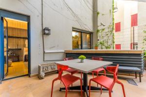 a dining room with a table and red chairs at Convivium 5 - High-end Studio in Gemmayze in Beirut