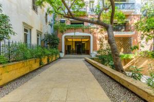 a walkway leading to a building with a tree at Convivium 5 - High-end Studio in Gemmayze in Beirut