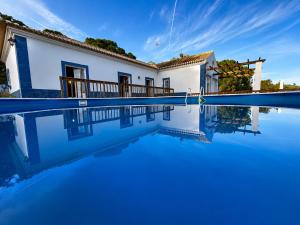 a villa with a pool in front of a house at Casa da Lua in Erra