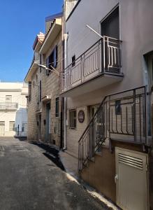 an empty street next to a building with a balcony at B&B Santa Filomena in Laterza
