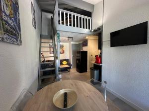 a living room with a table and a kitchen at Coul in Valras-Plage