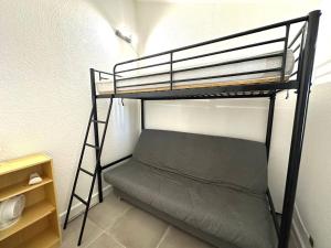 a bunk bed in a small room with a ladder at Coul in Valras-Plage +2 photos