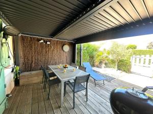 a patio with a table and chairs on a deck at Coul in Valras-Plage