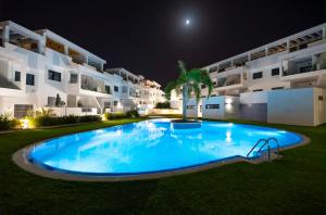 a large swimming pool in front of a building at night at Casa juley in Torrevieja