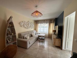 a living room with a couch and a chandelier at Desbo in Valras-Plage