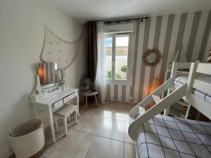 a bedroom with a bed and a desk and a bunk bed at Desbo in Valras-Plage +14 photos