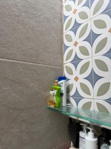 a bathroom shelf with products on it next to a wall at Manzanillo Homestay Room in Manzanillo