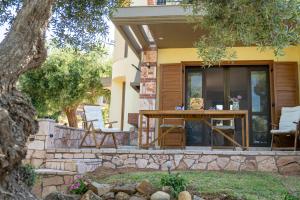 a patio with a table and chairs on a house at Halkidiki Kassandra villa 3P Exclusive Peace & Beautiful Sea Views in Agia Paraskevi