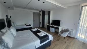 a bedroom with a bed and a television in it at AnDora in Donji Štoj