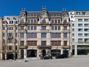 a large building with cars parked in front of it at The One Monumental Palace in Porto