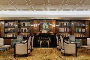 a room with a library with chairs and books at The One Monumental Palace in Porto