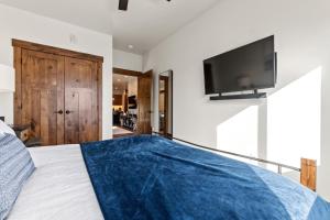 ein Schlafzimmer mit einem großen Bett und einem Fernseher an der Wand in der Unterkunft Baker Loft 201 in Whitefish