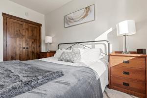 ein Schlafzimmer mit einem Bett und einer Holzkommode in der Unterkunft Baker Loft 201 in Whitefish