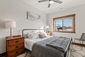 ein Schlafzimmer mit einem Bett, einem Deckenventilator und einem Fenster in der Unterkunft Baker Loft 201 in Whitefish