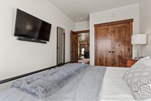 ein Schlafzimmer mit einem großen Bett und einem Flachbildfernseher in der Unterkunft Baker Loft 201 in Whitefish + 11 Fotos