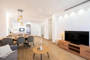 a living room with a dining table and a large television at Casa juley in Torrevieja