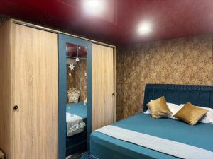 a bedroom with a bed with blue sheets and gold pillows at Arolen in Nesebar