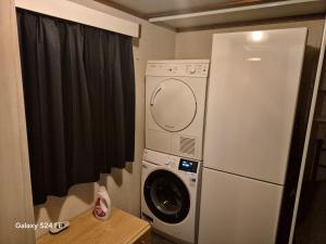 a refrigerator and a washing machine in a room at Chalet te huur op Camping de Kleine Wielen te Leeuwarden in Leeuwarden