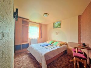 a small bedroom with a bed and a desk at U Nazara in Slavske +58 photos