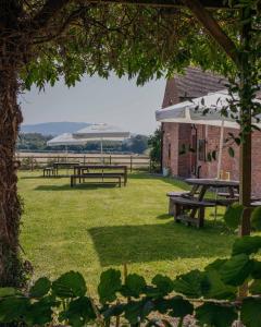 a picnic area with picnic tables and a building at The Haughmond in Upton Magna