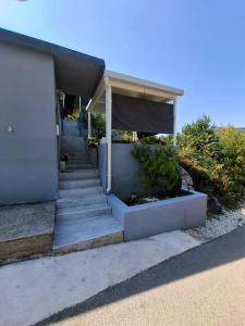 a house with stairs and a porch with a canopy at Apartman Jadranka in Rogotin +11 photos