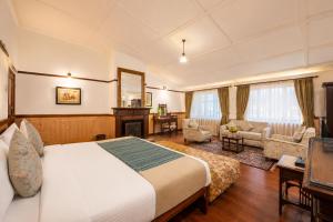 a hotel room with a bed and a living room at Springfields - A Heritage Palace Since 1902 by Eastlynn Experiences in Shimla
