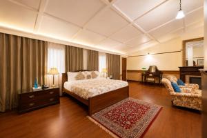 a bedroom with a bed and a chair and a desk at Springfields - A Heritage Palace Since 1902 by Eastlynn Experiences in Shimla